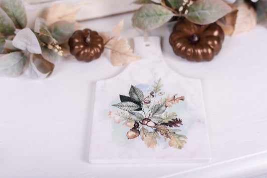 Woodland rectangular trivet or hot plate styled with foliage and pumpkins on wooden table