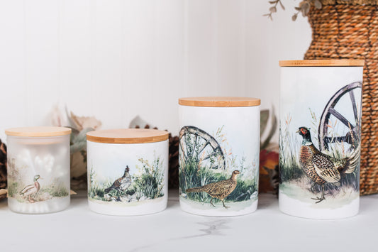 Set of ceramic canisters with game bird designs on a white surface