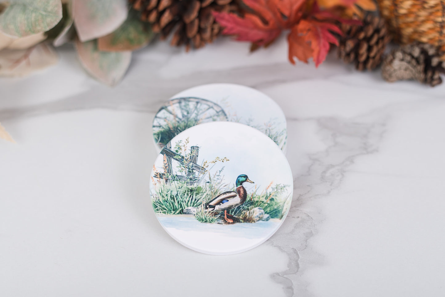 Round coaster with a duck design on a marble surface with decorative elements.