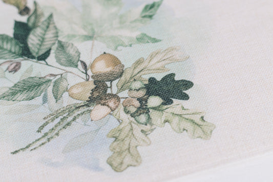 Set of neutral fall placemats with oak leaf prints on a table