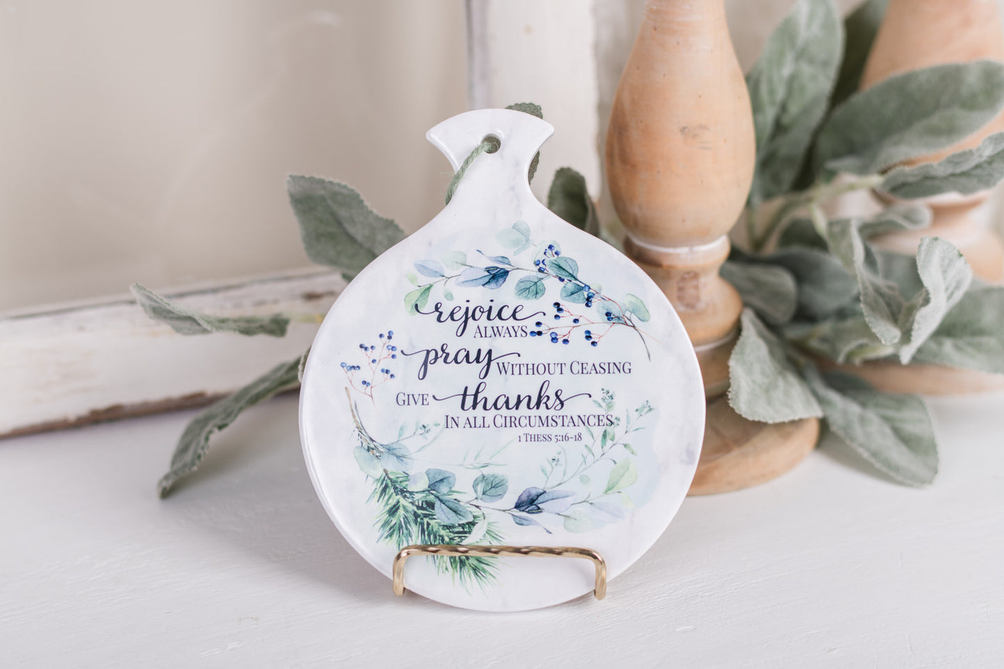 Faith-based ceramic spoon holder styled with winter greenery