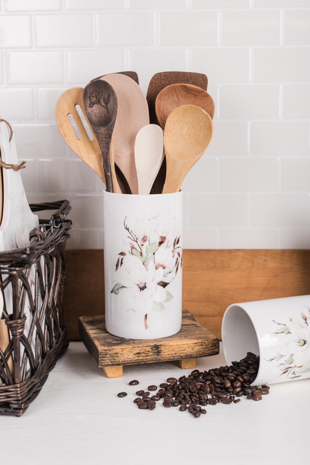 Ceramic magnolia utensil holder on kitchen counter with wooden spoons