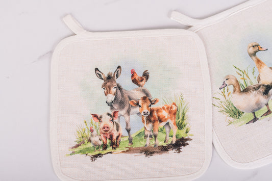 Set of two pot holders with farm animal designs on a white background