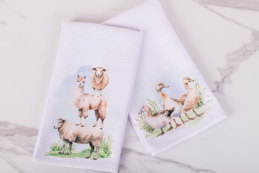 Farm animal tea towels styled on marble surface