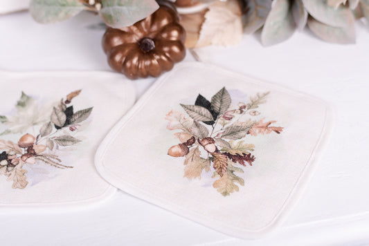 closeup of fall leaves and acorns on linen pot holders