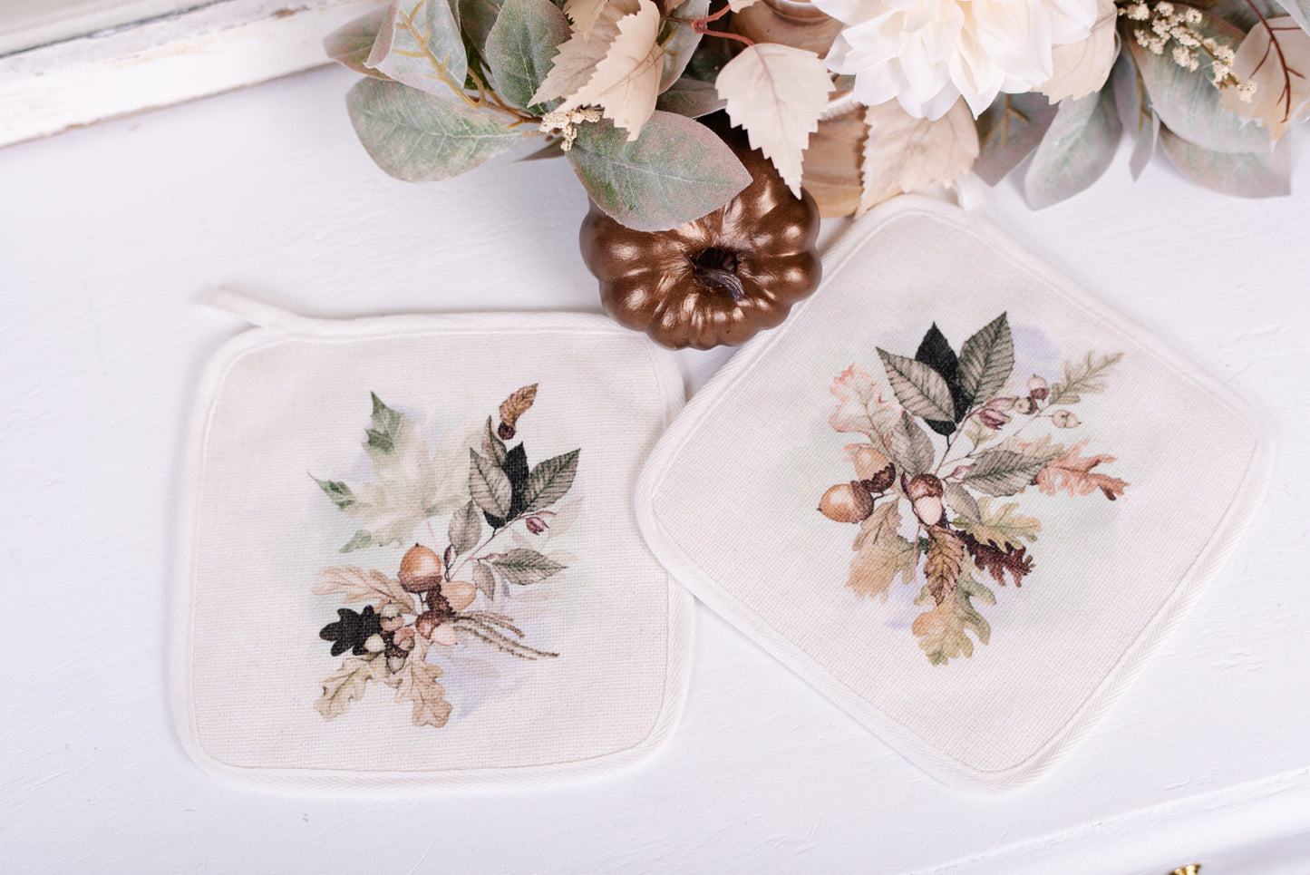 Woodland Collection pot holders on white background beside pumpkin and florals