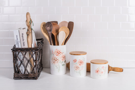 Tall ceramic floral crock styled with cutting boards, trivets, canisters and recipe books