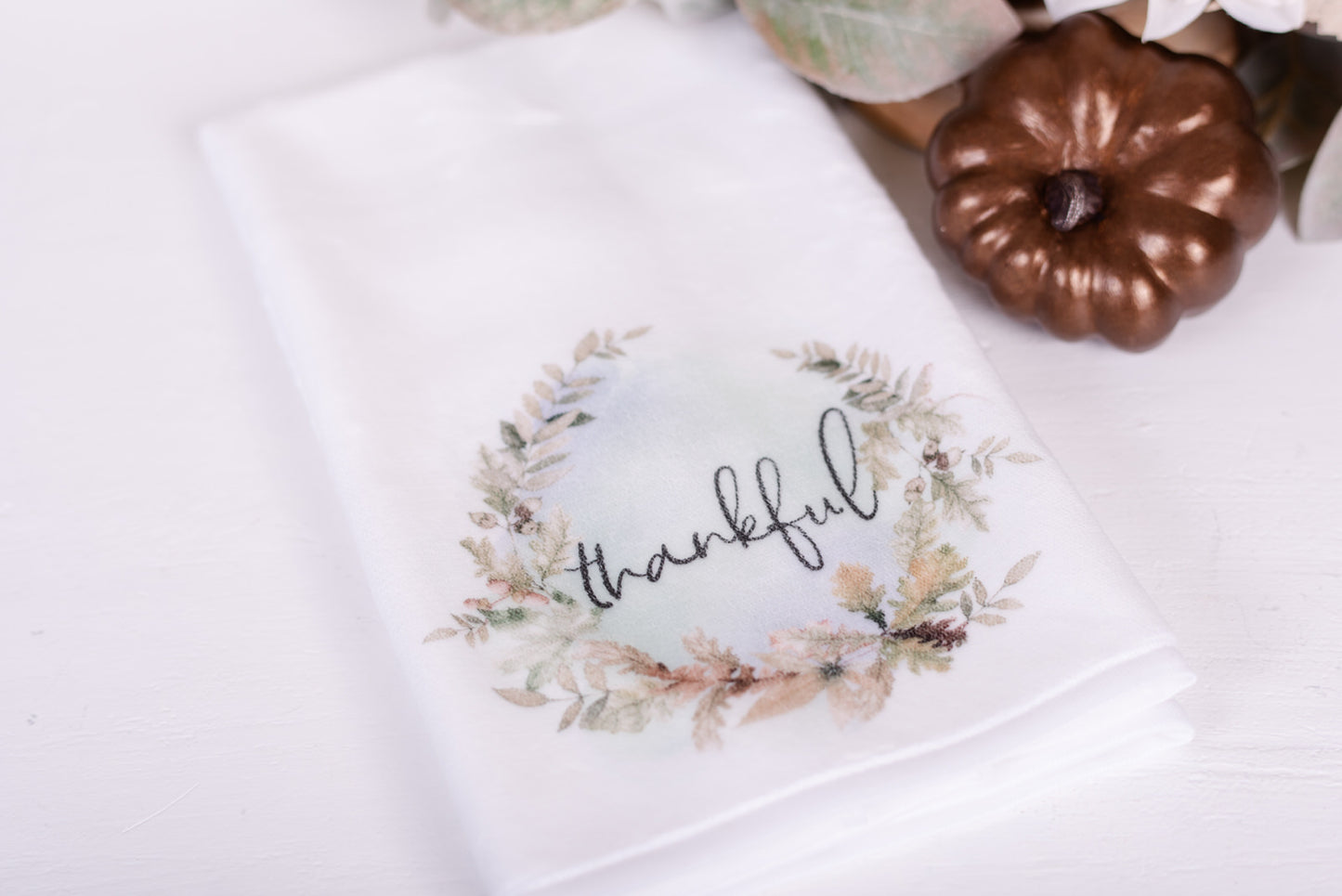 Woodland microfiber hand towel on white counter with bronze pumpkin and leaves