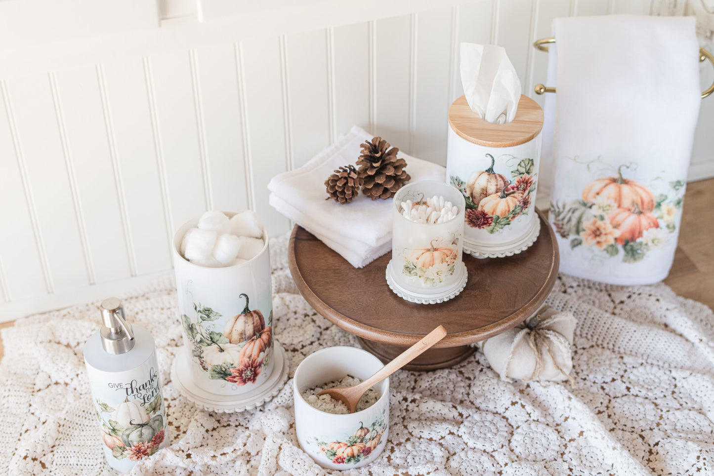 Decorative bathroom set with floral-themed containers on the counter with a doily
