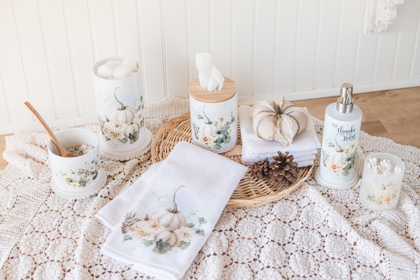 Decorative items include a towel, candles, a soap dispenser and bathroom containers on a crocheted tablecloth.