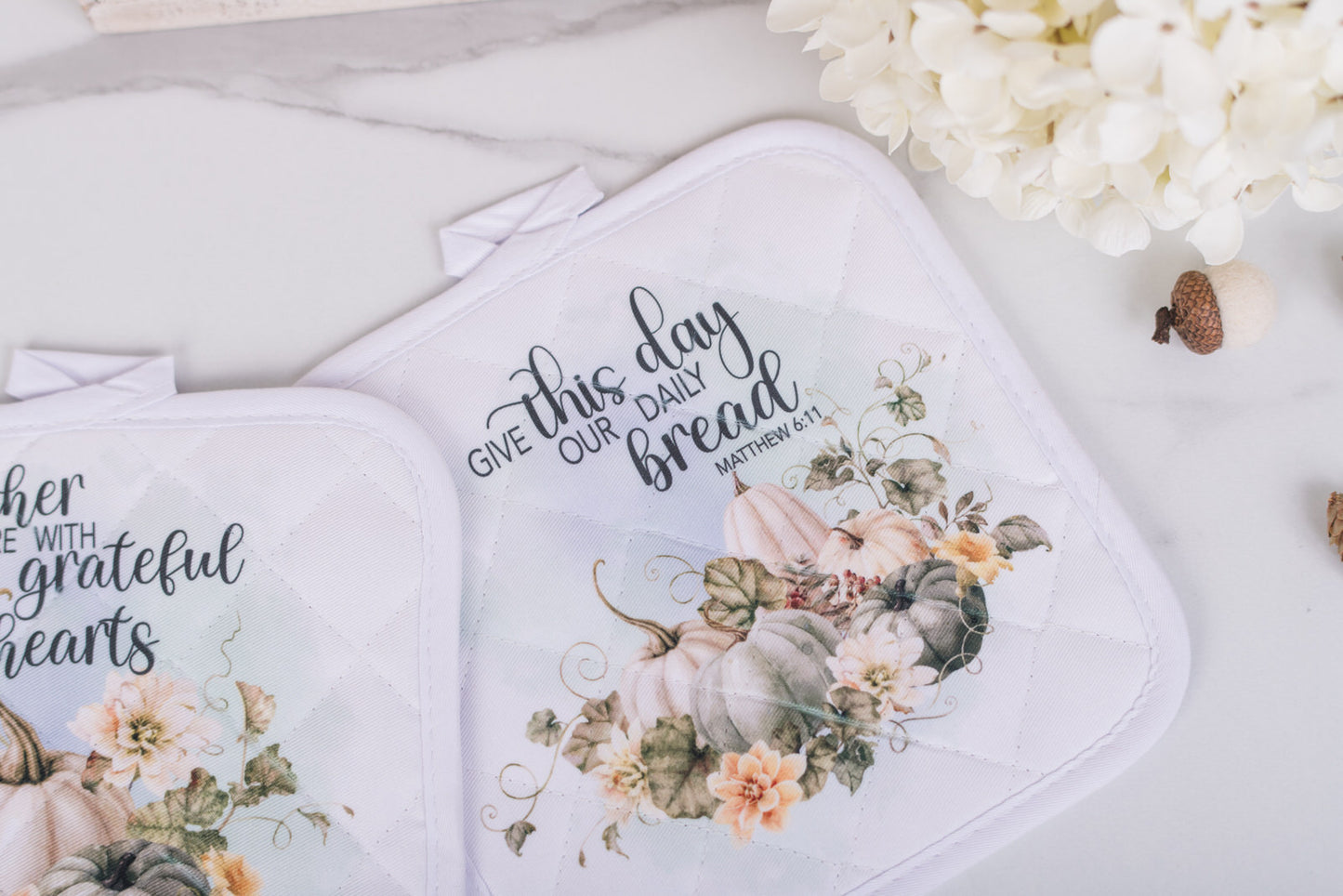 Scripture potholders with pastel pumpkins for fall kitchen decor, with the bible verse; Give Us This Day Our Daily bread,