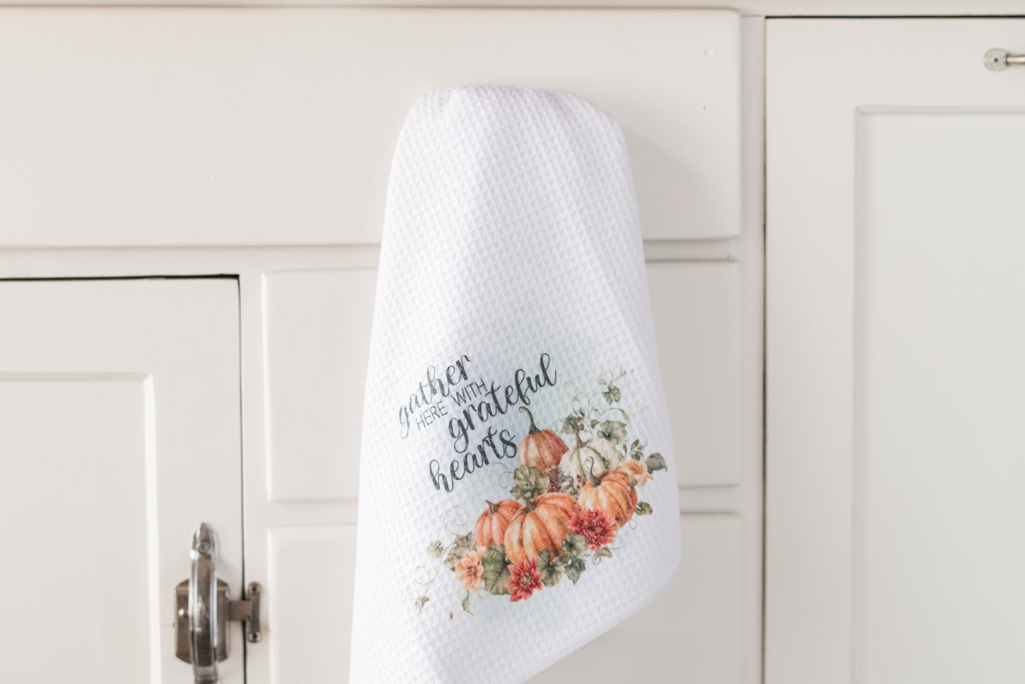 Tea Towels with pumpkins and scripture hanging on on a white cabinet handle