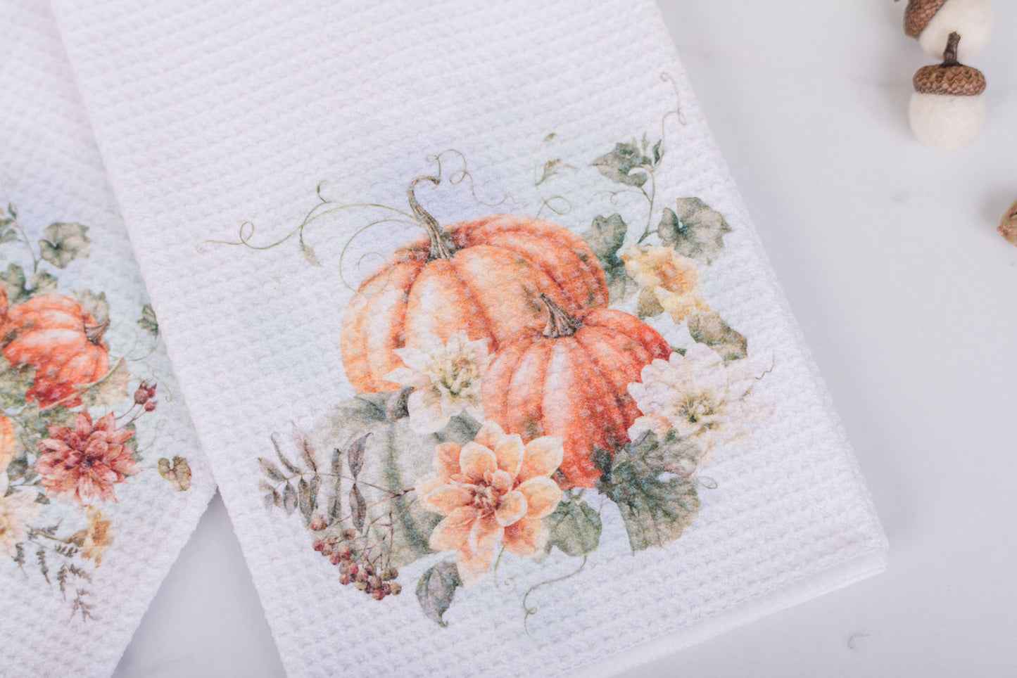 Autumn floral tea towel styled with acorns