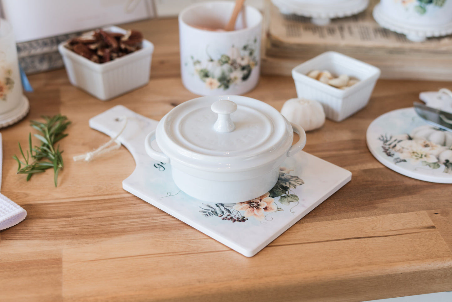 White ceramic pot with lid on a pumpkin trivet.