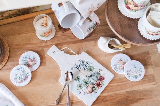 Warm-toned fall trivet styled with pumpkins and flowers with coffee kitchen decor