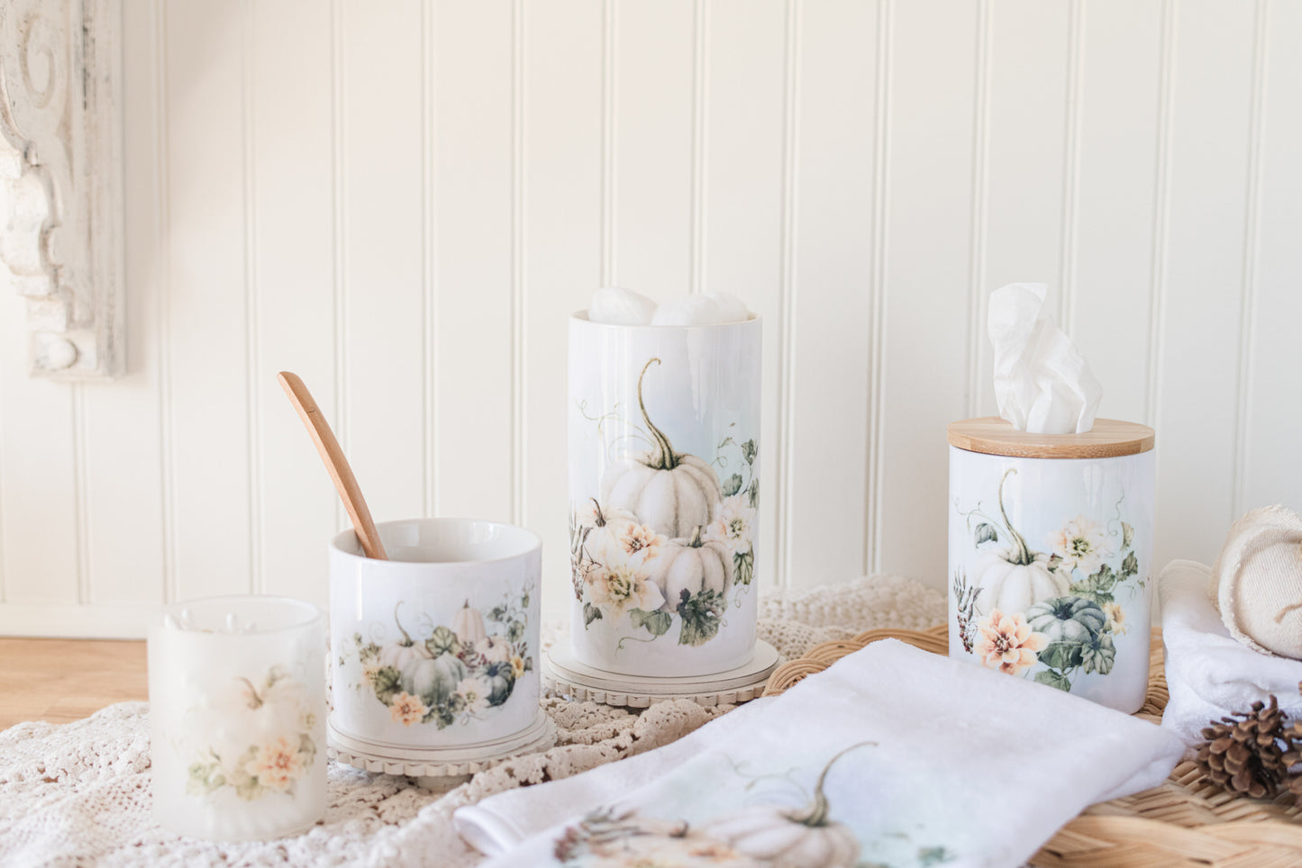 Decorative tissue holder with floral and pumpkin designs on a wooden surface.