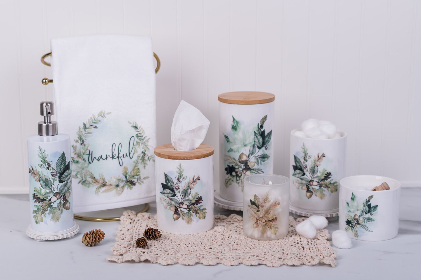 Decorative home accessories with leaf and acorn designs on a white surface.