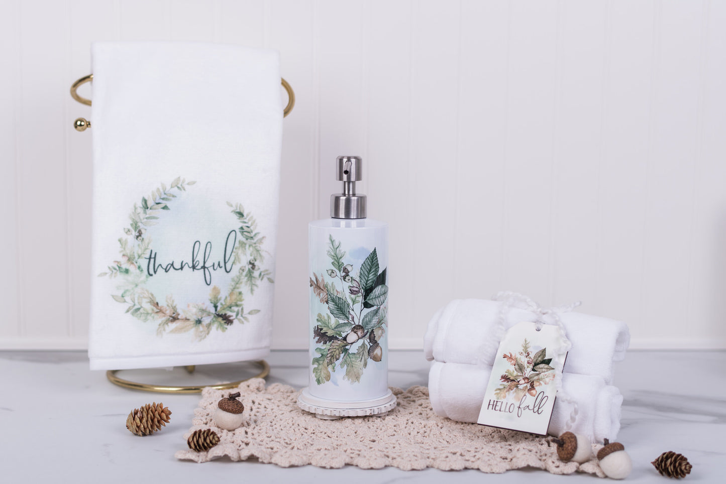 Bathroom set with towels, soap dispenser, and decorative items on a light background