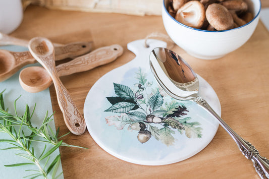 Round ceramic spoon rest with oak leaves styled on autumn kitchen counter