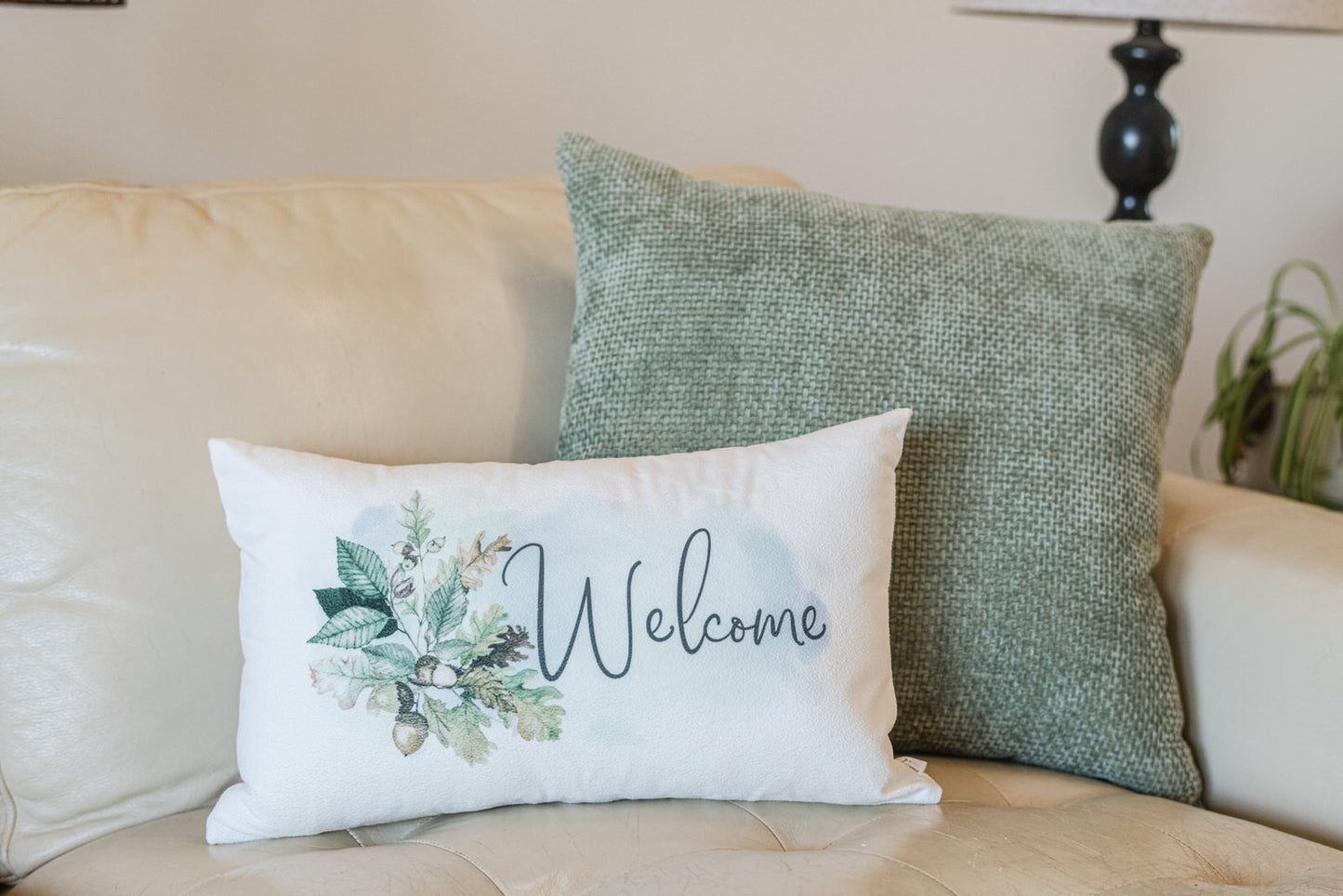 Decorative pillows on a couch with one featuring a 'Welcome' design.