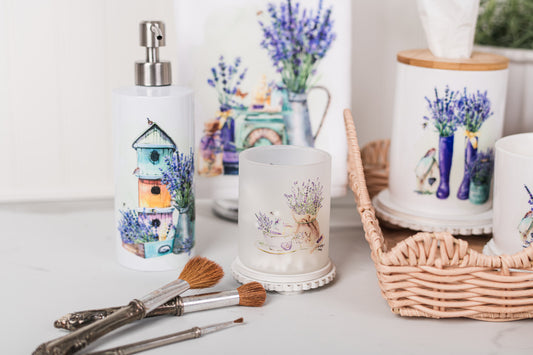 Decorative items including a candle, soap dispenser, and small plants on a white surface.