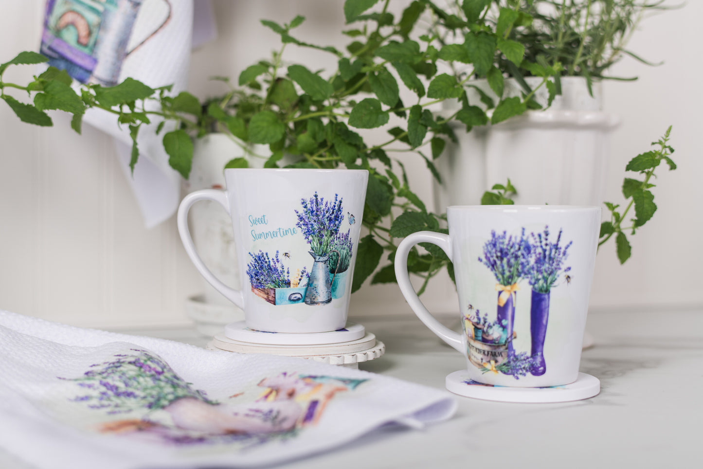 Two mugs with lavender designs on a table with plants in the background