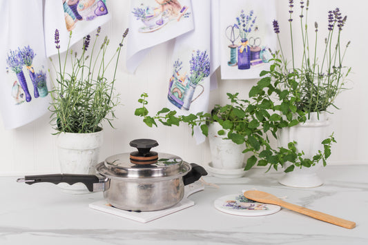 Kitchen setting with pots of herbs and a pot on a white surface.