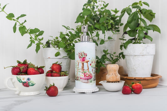 Decorative soap bottle with strawberry design on a table with potted plants and strawberries.