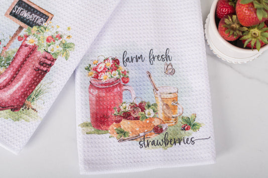 Decorative kitchen towel with strawberry-themed design on a white surface
