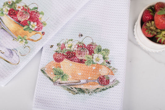 Decorative kitchen towels with fruit and floral design on a white surface