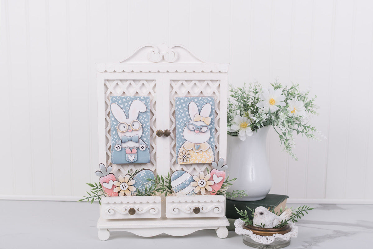 Decorative cabinet with Easter-themed decorations on a white surface