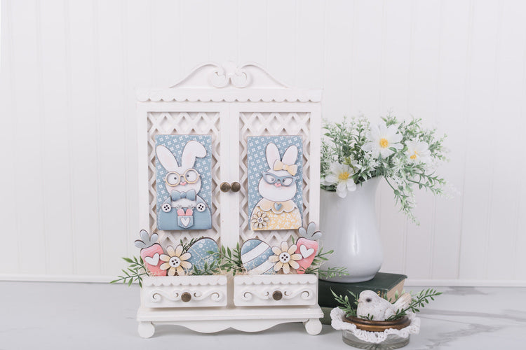 Decorative cabinet with Easter-themed decorations on a white surface
