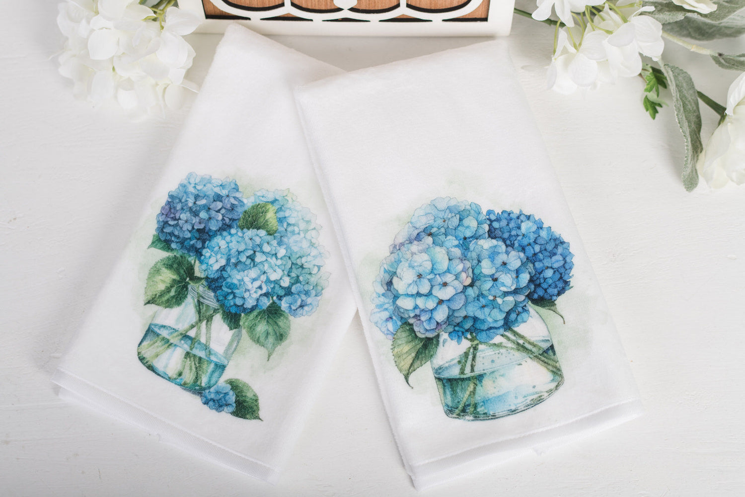 Soft, velvety, white bathroom, hand towels, with blue hydrangeas in a jar 