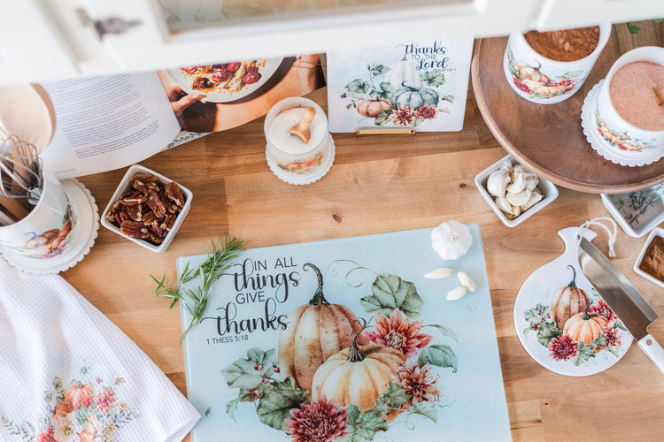 Soft fall tea towels and trivets styled with a glass cutting board on a butcher block