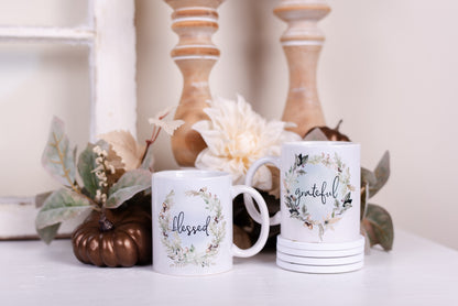 Woodland mug set with Blessed and Grateful wreath designs styled with stacked coasters and fall greenery