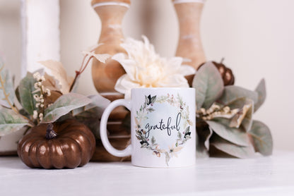 grateful fall coffee mug styled with greenery and a pumpkin