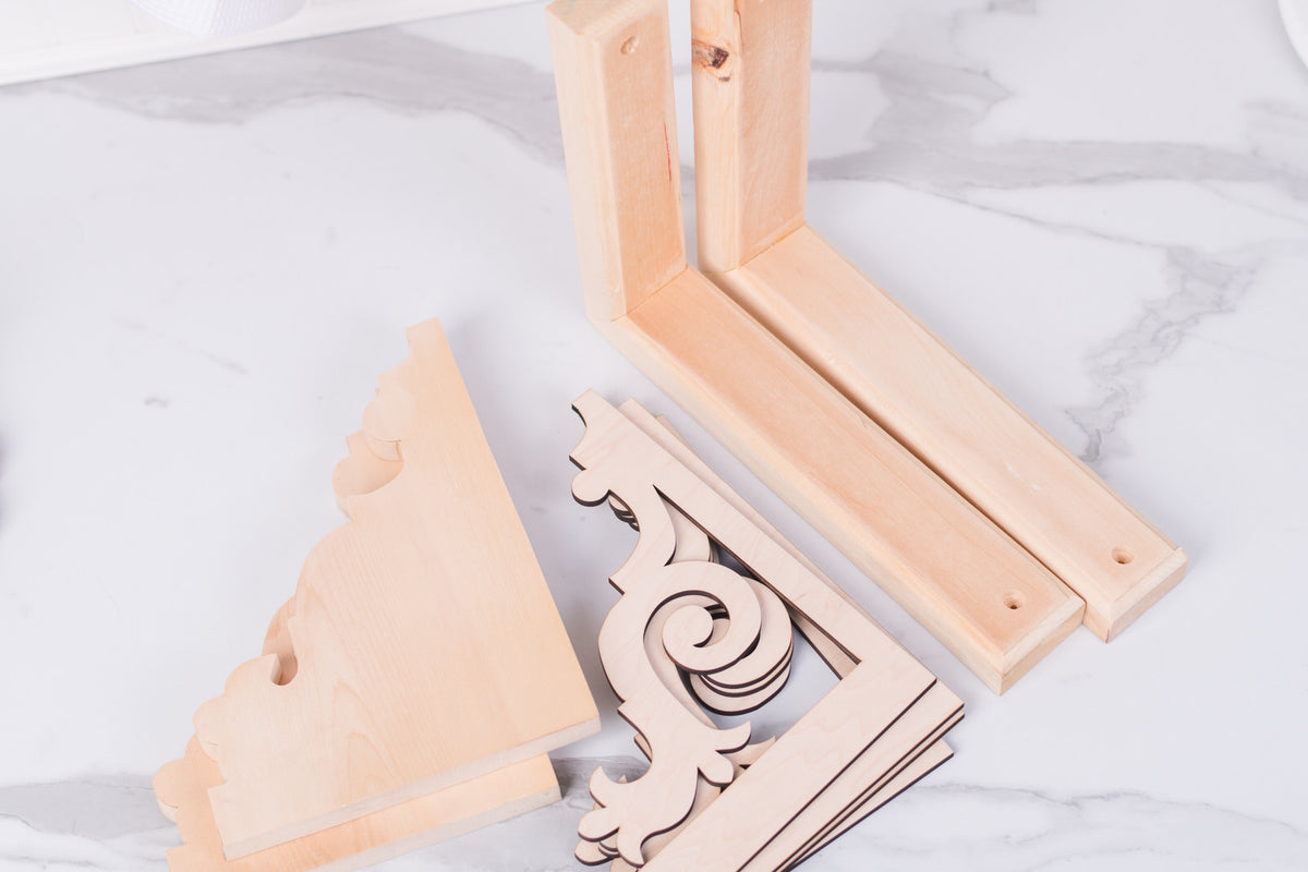 Wooden corbel DIY elements on a white marble surface