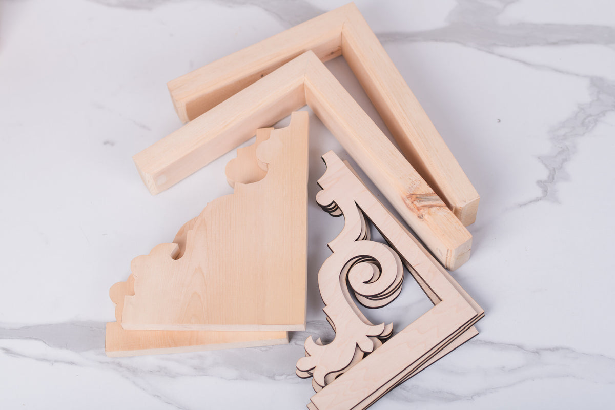 Wooden decorative corner brackets on a marble surface