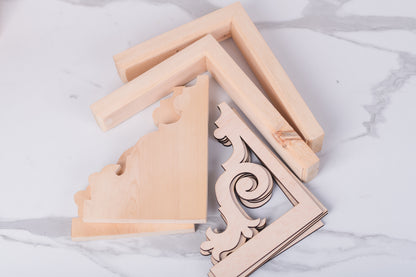 Wooden decorative corner brackets on a marble surface