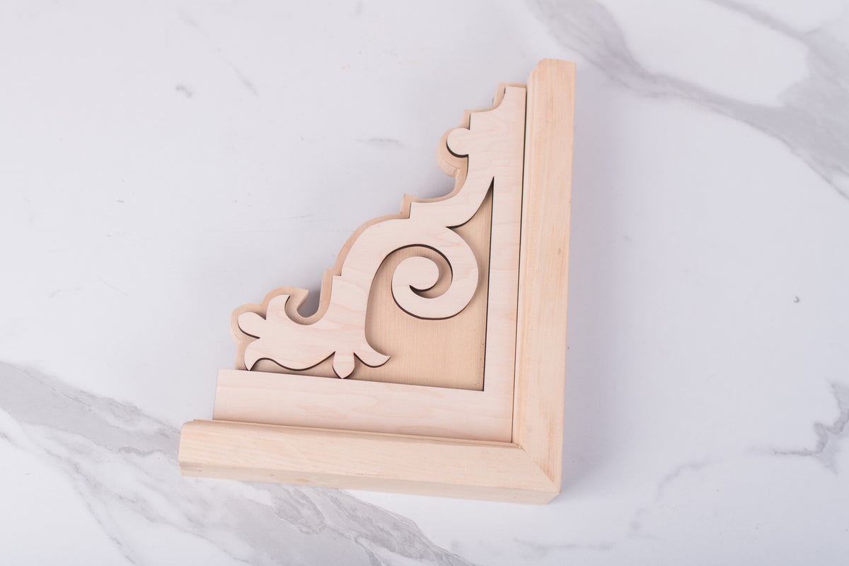 Decorative wooden corner bracket on a marble surface