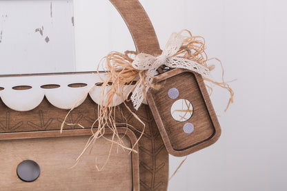 Wooden decorative item with a tag and string on a white background