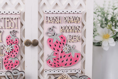 Decorative sign with pink strawberries and text on a white background