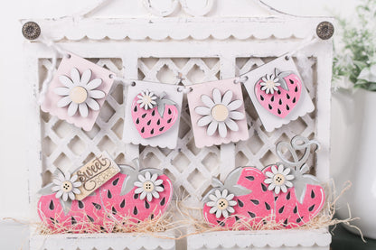 Decorative cutouts of fruits and flowers on a white lattice background