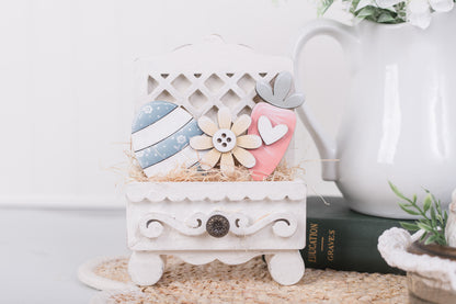 Decorative white box with pastel-colored easter inserts on a textured surface