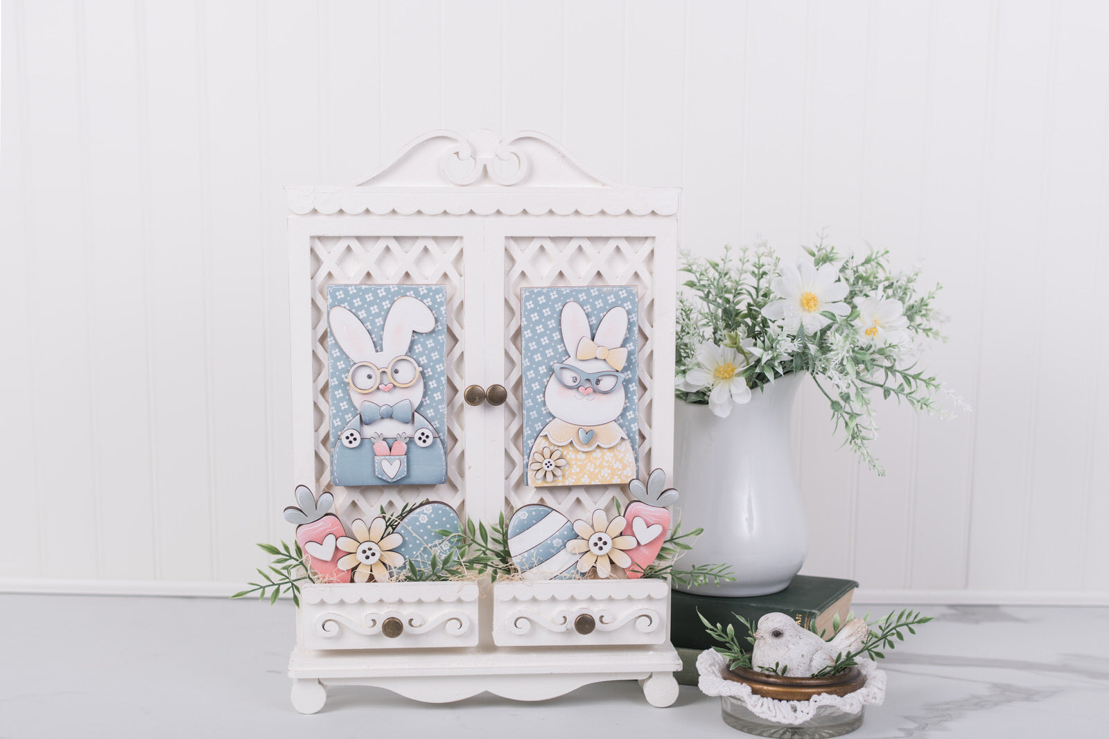 Decorative cabinet with Easter-themed decorations on a white surface