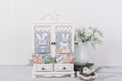 Decorative cabinet with Easter-themed decorations on a white surface