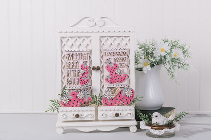 Decorative white cabinet with strawberry interchangeable designs on a white background