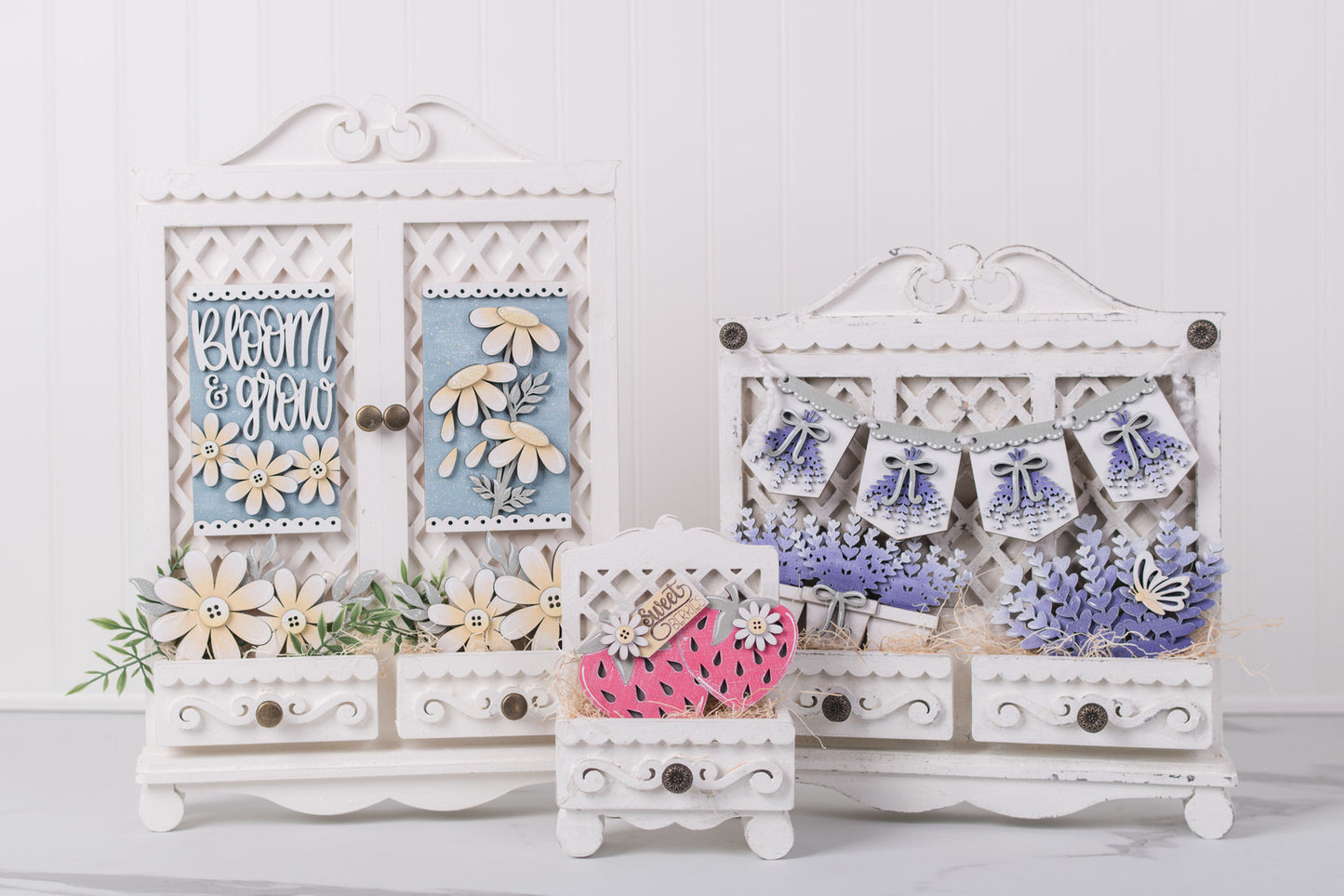 Decorative white wooden interchangeable DIY cabinet swith floral and text designs on a light gray background