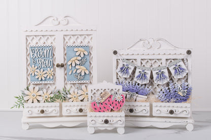 Decorative white wooden interchangeable DIY cabinet swith floral and text designs on a light gray background
