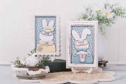 Two framed illustrations of bunnies with decorative elements on a white surface.